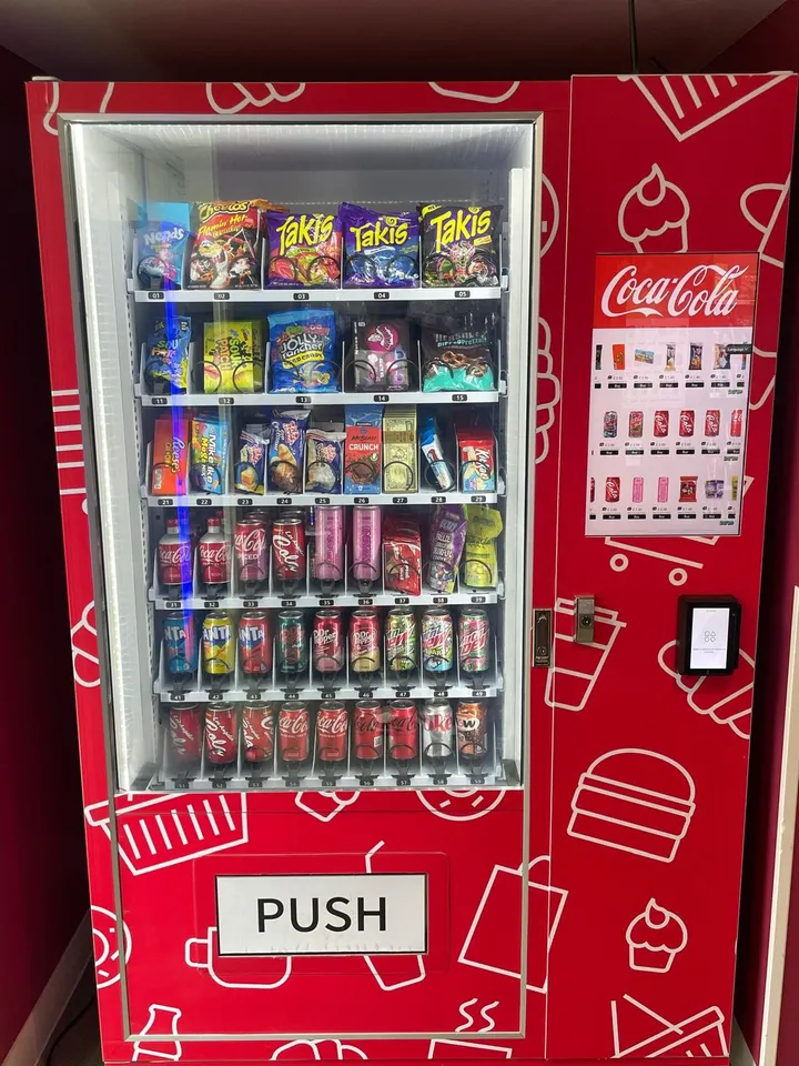 Red branded snack and drink machine stocked with snacks and drinks