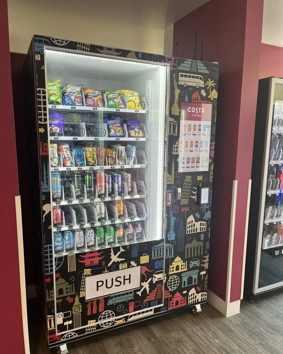 JV A11 chilled snack and drink vending machine with a travel-themed wrap, stocked with snacks and drinks