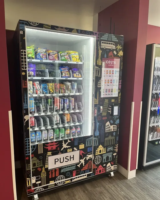 JV A11 chilled snack and drink vending machine with a travel-themed wrap, stocked with snacks and drinks
