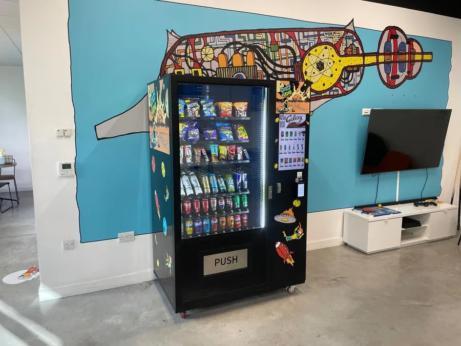 Fully managed snack vending machine with a colourful mural wrap in a bright office